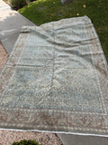 Persian Tabriz area rug from the 1940s hand knotted in wool with muted green, ivory, khaki and beige tones.