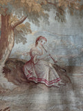 Close up of woman playing wind instrument on antique pictorial tapestry.