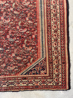 Close-up of intricate floral and paisley pattern on antique Ferahan rug

