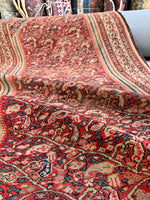 Vintage Persian rug with scrolling paisleys and muted color palette

