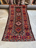Full view of antique Kazak runner with diamond medallions on a blue field.