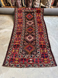 Full view of antique Kazak runner with diamond medallions on a blue field.