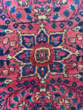Close up of medallion in small antique Persian accent rug with a richly patterned floral field and border.