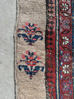 Antique runner with blossom-laden vine border design.