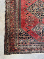 Corner view of floral and leaf border pattern on antique Afshar rug.