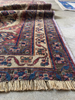 Afshar tribal rug bordered with intricate geometric floral patterns.