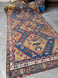 Hand-knotted Persian area rug displaying symbolic peacocks, animal motifs, and a woman figure.