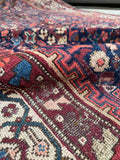 Persian rug with aqua blue, burgundy, and teal tones.