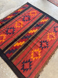 Antique Anatolian flatweave rug with serrated medallions in saffron and navy against a deep red field.