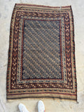 Decorative vintage tribal rug with intricate patterns on a concrete floor