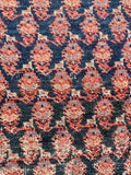 Close-up of a vintage persian rug boteh paisley  with red, blue, and beige colors.