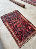 full picture of antique Persian Malayer rug showing navy field with saturated coral motifs
