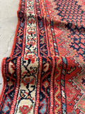 Close up of vintage Persian runner rug navy and red boteh field with zigzag chevron outline 