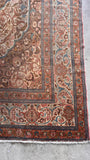 Corner view of antique 1920s Persian Tabriz rug showcasing intricate curvilinear floral motifs and mellow gold accents.