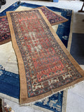 Diagonal view highlighting colorful paisley rows and camel border band.