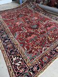 Antique 1930s Persian geometric rug with bold tribal motifs on a rich red field.
