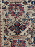 Close up view of worn antique Afshar rug handwoven with vegetable dyed wool.