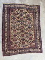 Handwoven Persian Afshar rug with worn patina and soft muted colors.