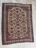 Handwoven Persian Afshar rug with worn patina and soft muted colors.