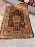 Hand knotted 4x6 wool rug showcasing natural color shifting nap and dark brown accents.