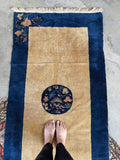 Vintage Chinese Nichols rug featuring central round botanical medallion on dark navy ground.