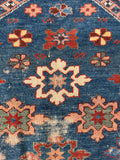 Close up of a 1920s antique Caucasian prayer mat displaying authentic age and character.
