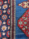 Antique blue Persian runner with stylized fish motifs, flowers and angular vines.