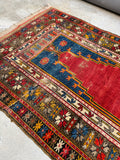 Vintage tribal rug displaying low pile wool texture.
