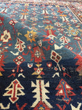 Worn antique Caucasian rug with visible character and low pile from over a century of use.