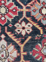 Close up view of antique Caucasian rug with alternating color combinations in lattice.
