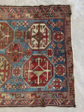 Detail of tribal motifs and geometric elements woven into an antique Caucasian rug field.