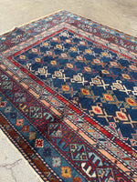 Soft low pile Caucasian rug with intricate mountain nomad design.