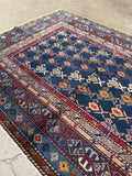 Soft low pile Caucasian rug with intricate mountain nomad design.