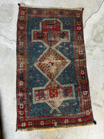 Love-worn antique rug showing low pile from years of use.