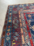Antique Caucasian rug with running water motif in the border.