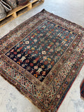 Antique 1880s Caucasian rug with rows of tribal motifs across a moody blue field with beautiful abrash.