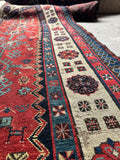 Antique Caucasian village runner with handwoven tribal borders and historic character.