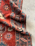 Handmade early 1900s Caucasian runner featuring classic tribal border details.