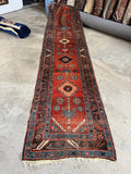 Antique early 1900s Caucasian tribal runner with rust field and sky blue geometric motifs.