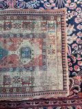 Historic 19th-century antique rug capturing unique color shifts, worn low pile, and village art heritage.