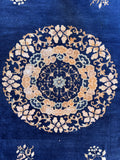 1930s vintage Chinese Peking rug close-up of the center floral rosette medallion and soft cloud-band motifs.