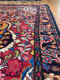 Antique floral Persian rug with clover style central medallion and saturated natural dyes.