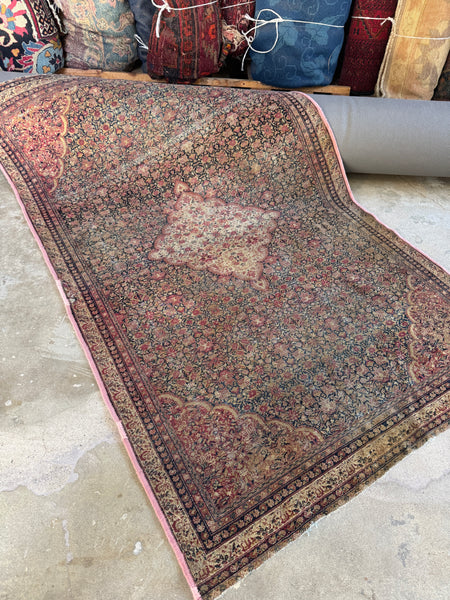 Antique Persian Ferahan rug from the 1880s with ivory medallion and detailed floral field.