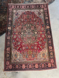 Finely woven Persian rug featuring a central medallion with ivory spandrels and ornate floral art patterns.