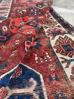 Wool runner featuring tribal motifs woven into the design with a floppy handle.