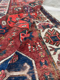 Wool runner featuring tribal motifs woven into the design with a floppy handle.