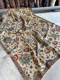 Ivory ground rug with interlocked design and rich colors.
