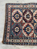 Caucasian tribal runner rug with repeating medallions and folk style motifs.