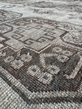 Handmade Persian Shiraz area rug with low pile and earthy tones.