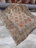 Farmhouse chic rug styled flat showcasing neutral earth tones, orange accents, and natural fading.